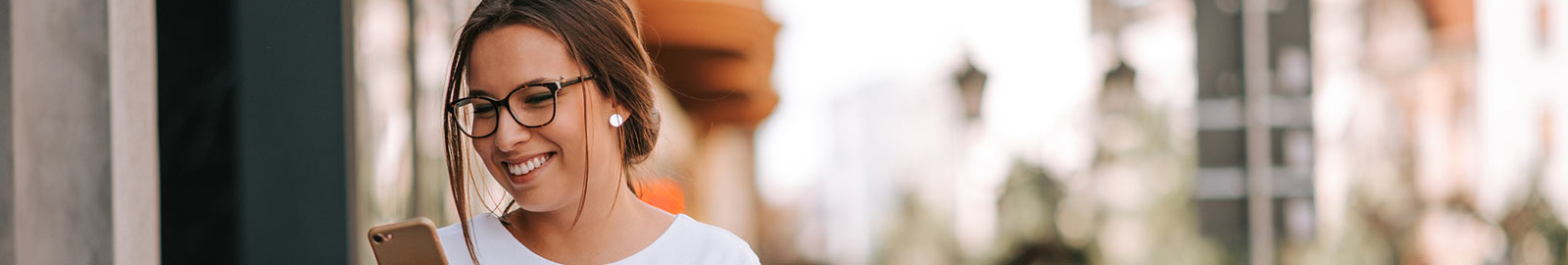 Woman looking at phone outdoors.