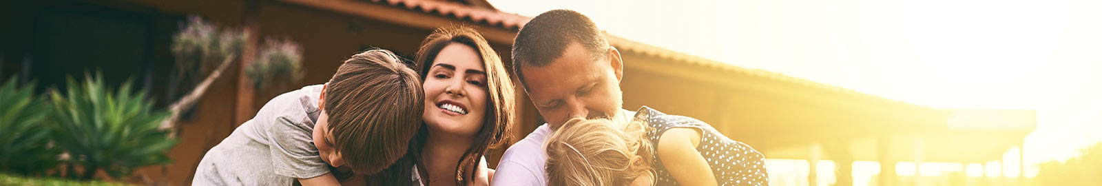 Parents and two kids in front of house.