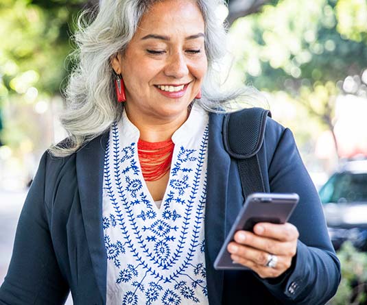 Woman walking looking at phone.